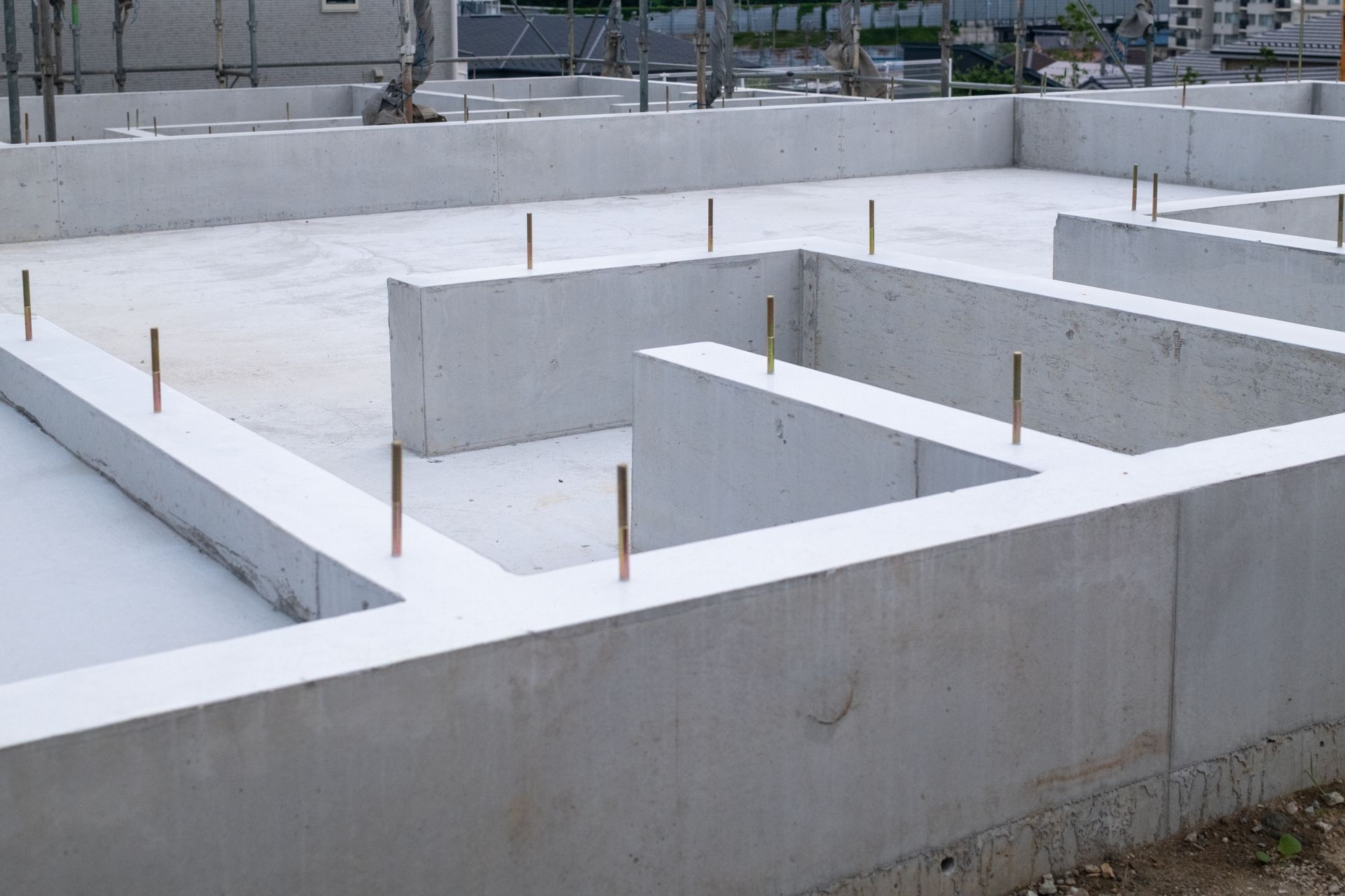 Concrete foundation walls with protruding rebar at a construction site
