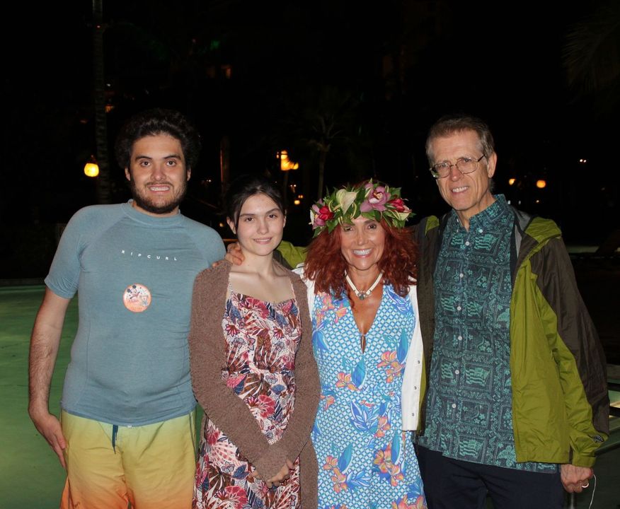 A group of people posing for a picture with one wearing a flower crown