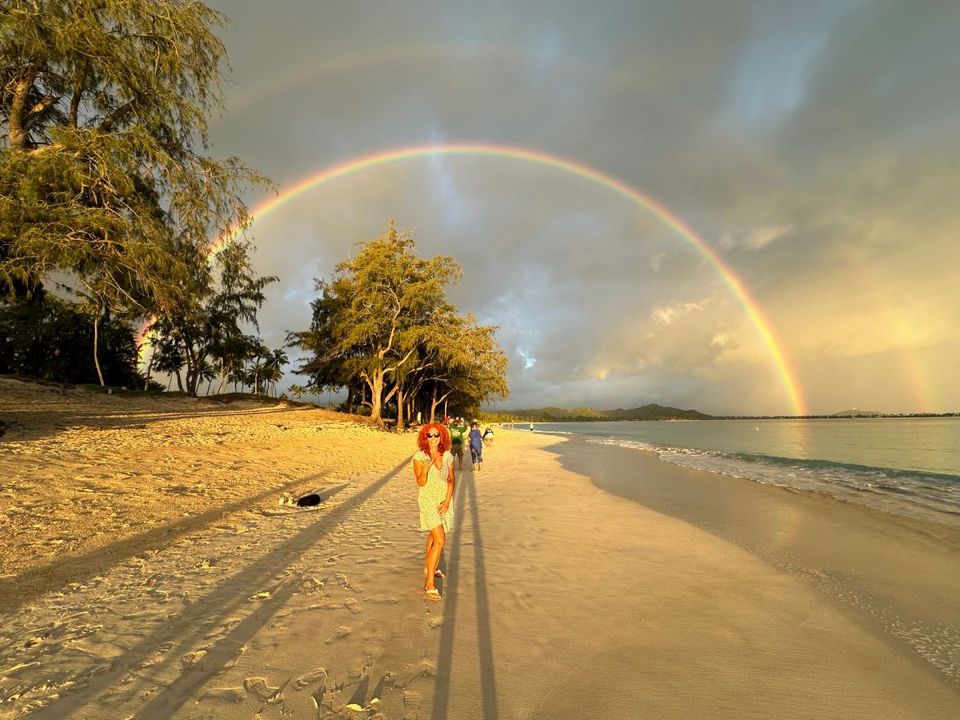 Yolanda at the beach with rainbow behind