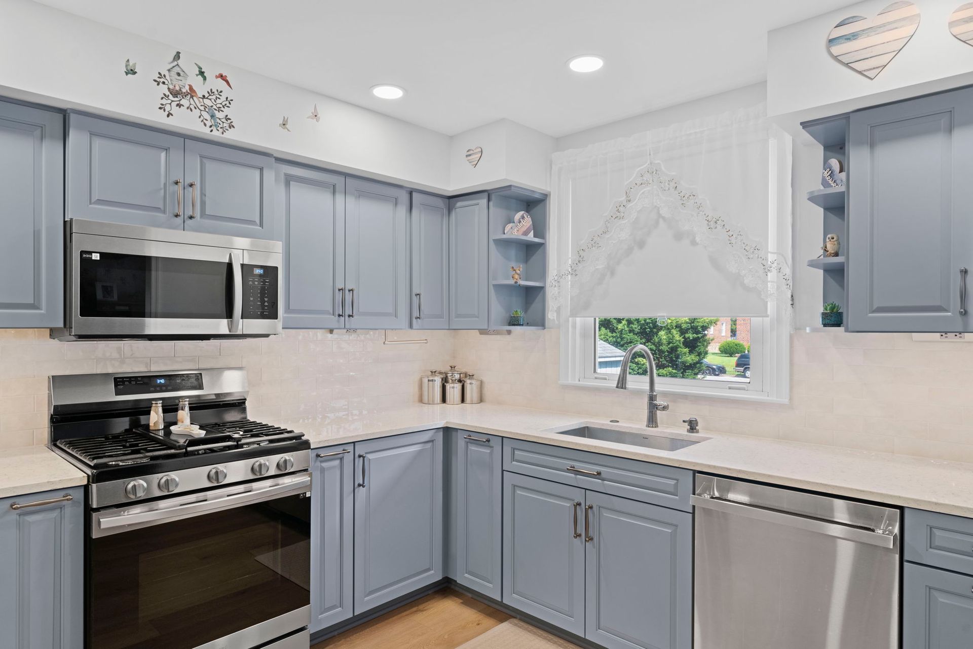 Bright kitchen with blue cabinets, stainless appliances, and a window over the sink In Bucks County PA
