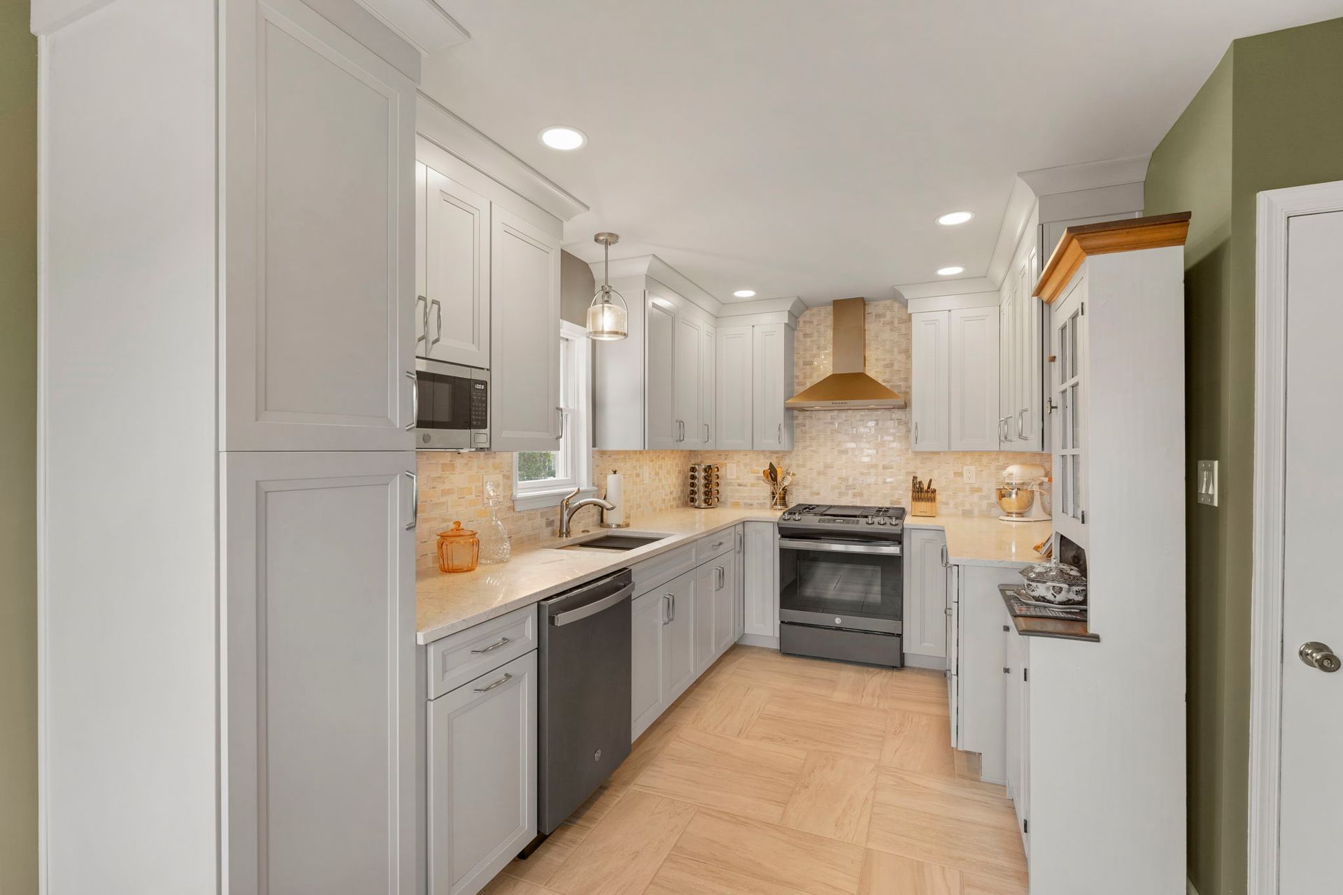 Bright modern white kitchen with stainless steel appliances and light wood floor In Bucks County PA