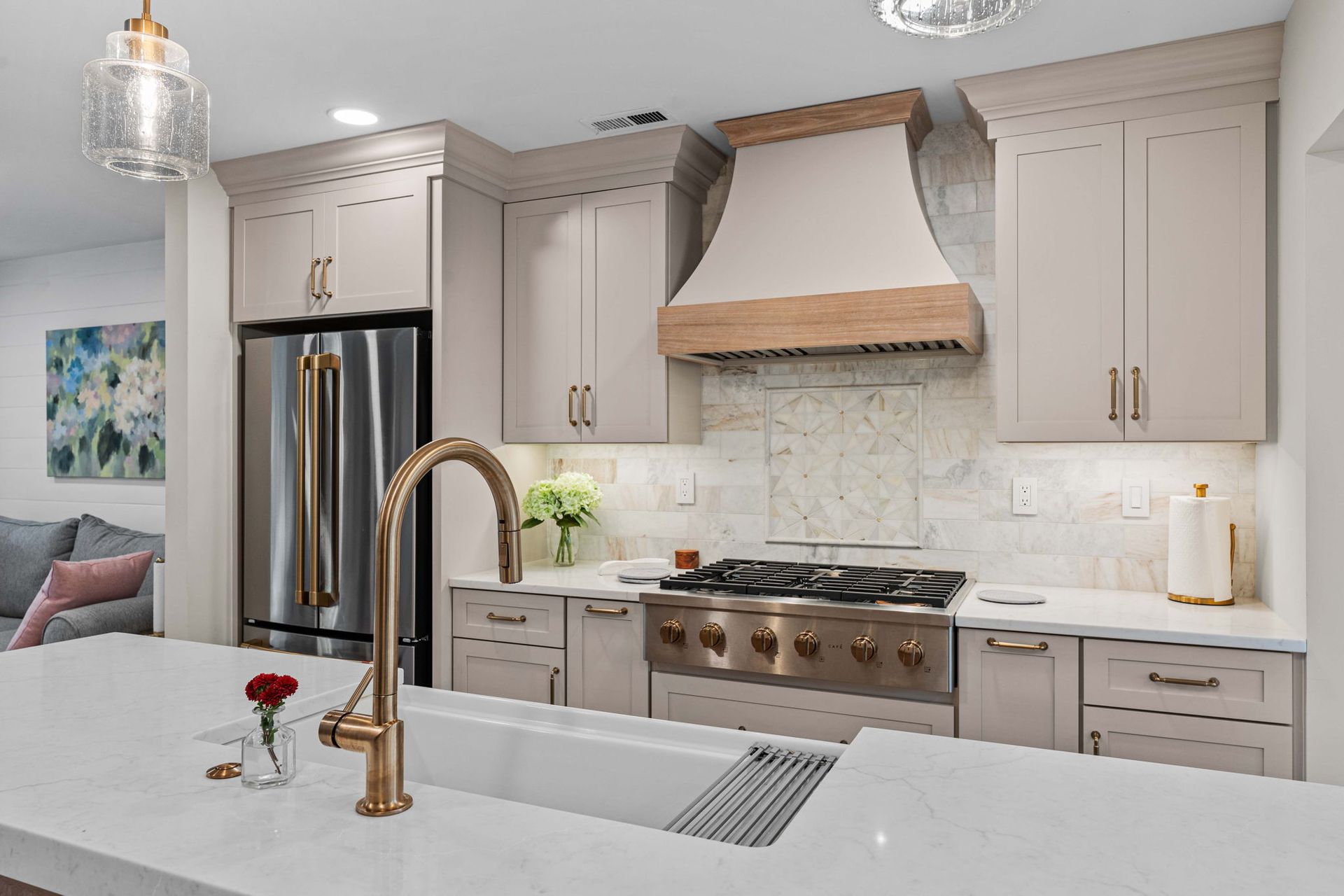Modern kitchen with beige cabinets, stainless steel appliances, white island, and gold faucet in Bucks County PA