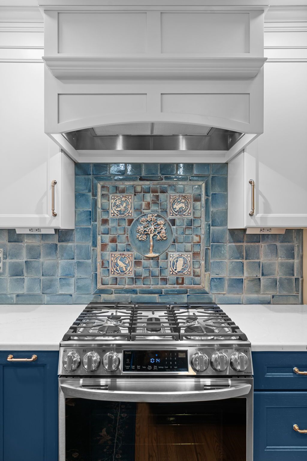 Modern kitchen with stainless steel range, blue tile backsplash, and white hood  In Bucks County PA