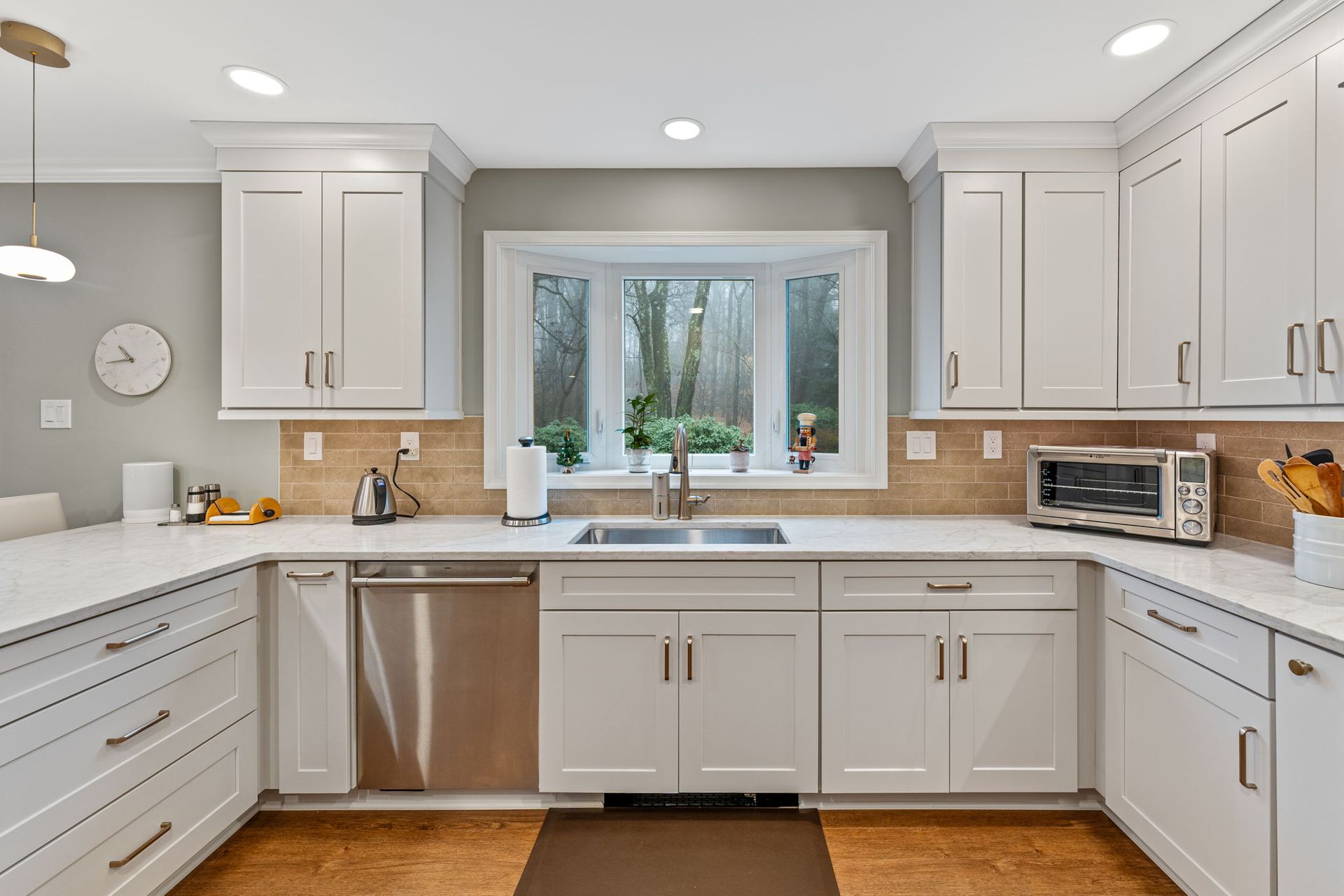 Bright modern kitchen with white cabinets, stainless appliances, and a window over the sink In Bucks County PA