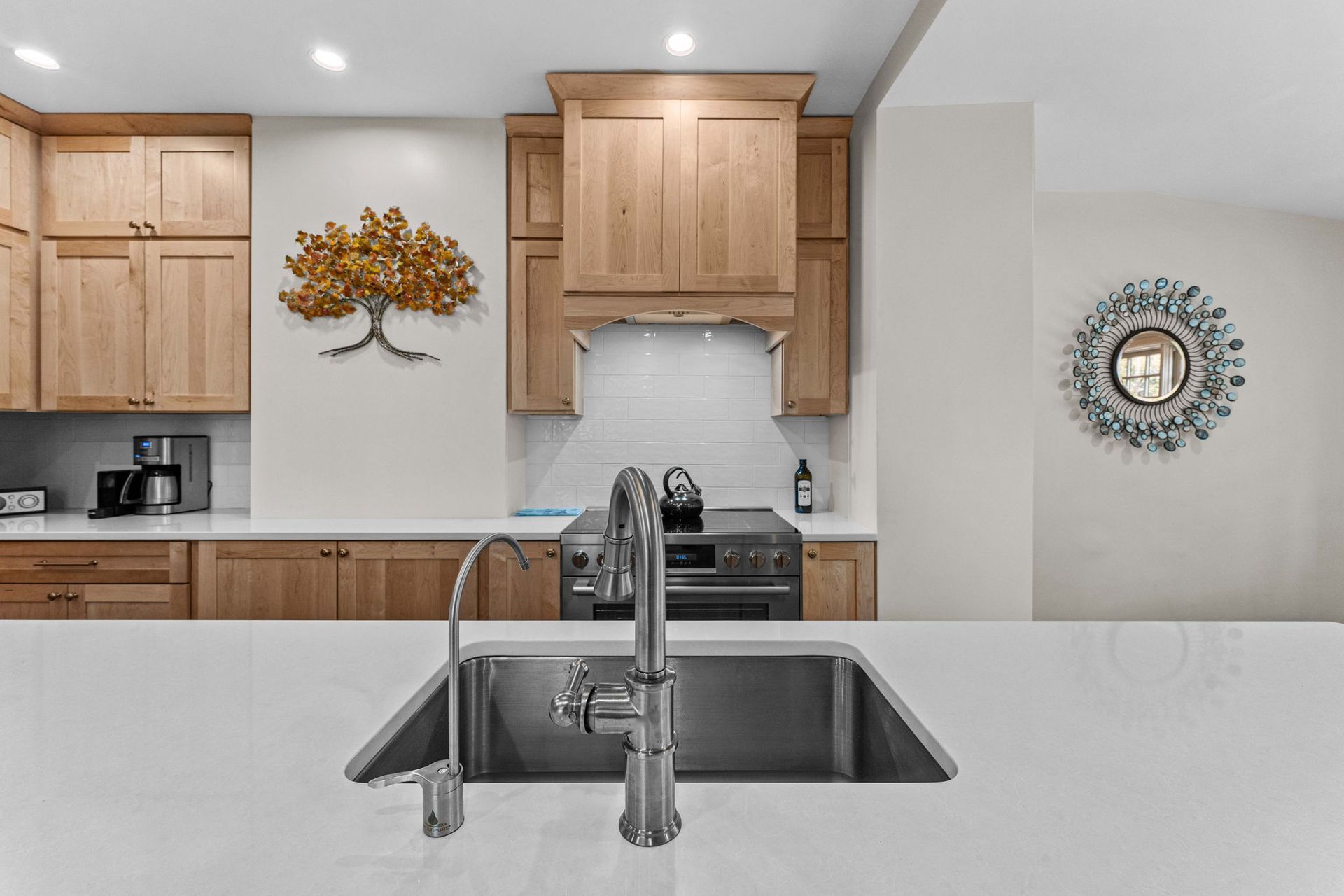 Modern kitchen with wood cabinets, stainless sink and appliances, and decorative wall accents In Bucks County PA