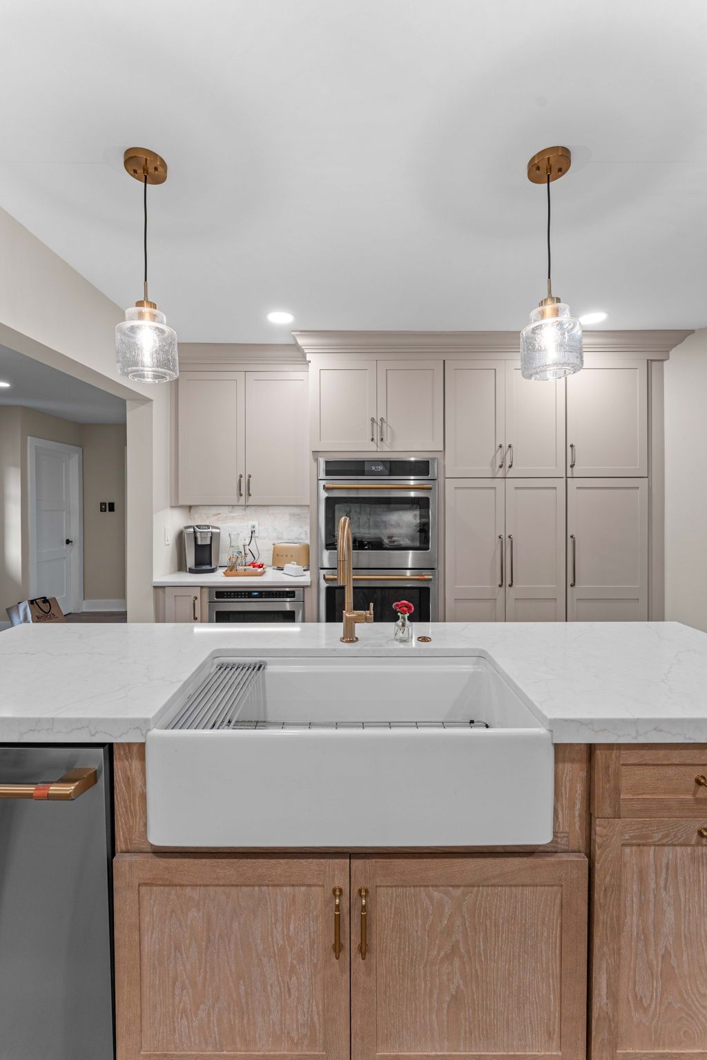 Modern kitchen with white cabinetry, large island sink, stainless oven, and two pendant lights in Bucks County PA