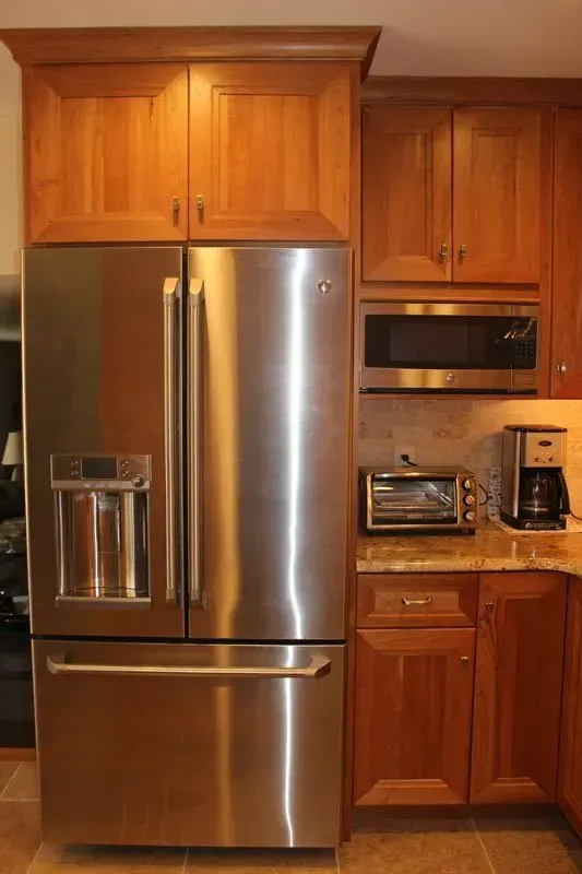 Kitchen with stainless steel refrigerator, microwave, toaster oven, coffee maker, and wooden cabinets In Richboro PA