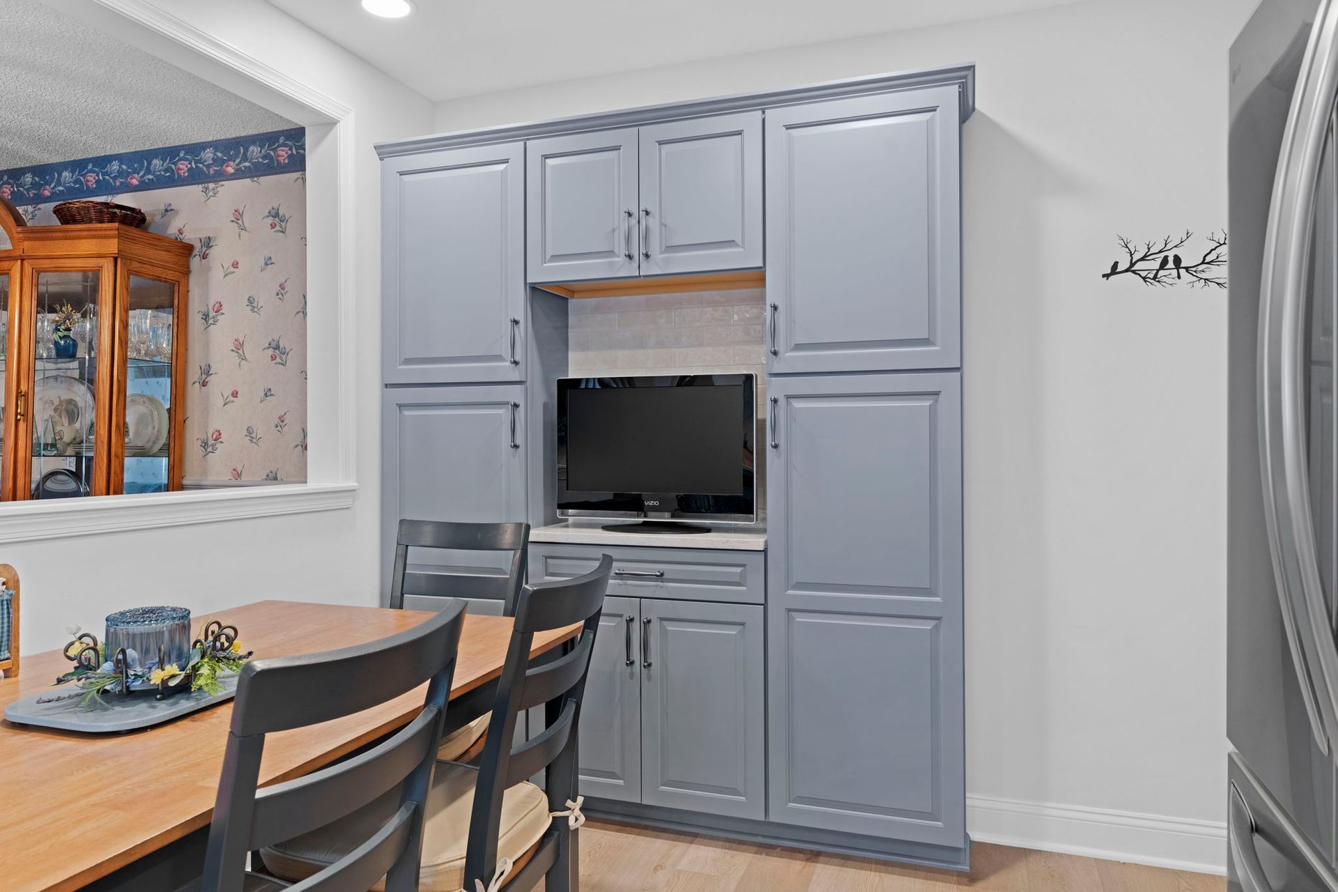 Dining room with blue built-in cabinets and a TV alcove beside a table and chairs In Bucks County PA
