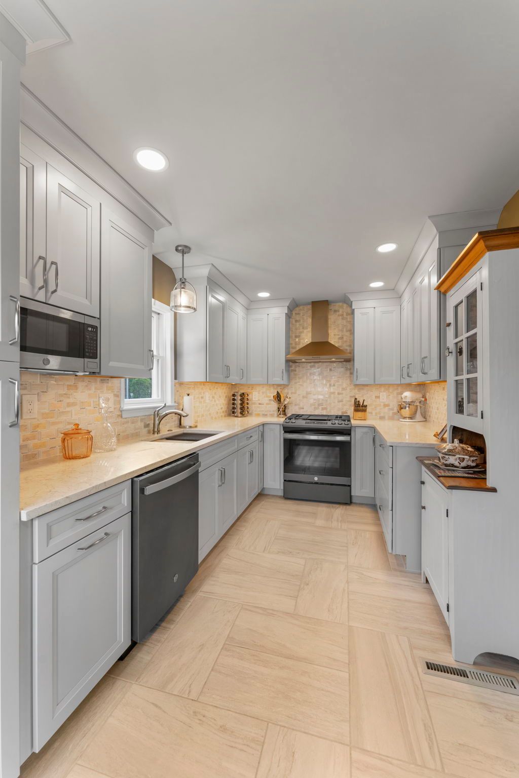 Bright modern kitchen with white cabinets, gray lower cabinets, and beige tile floor In Bucks Country PA