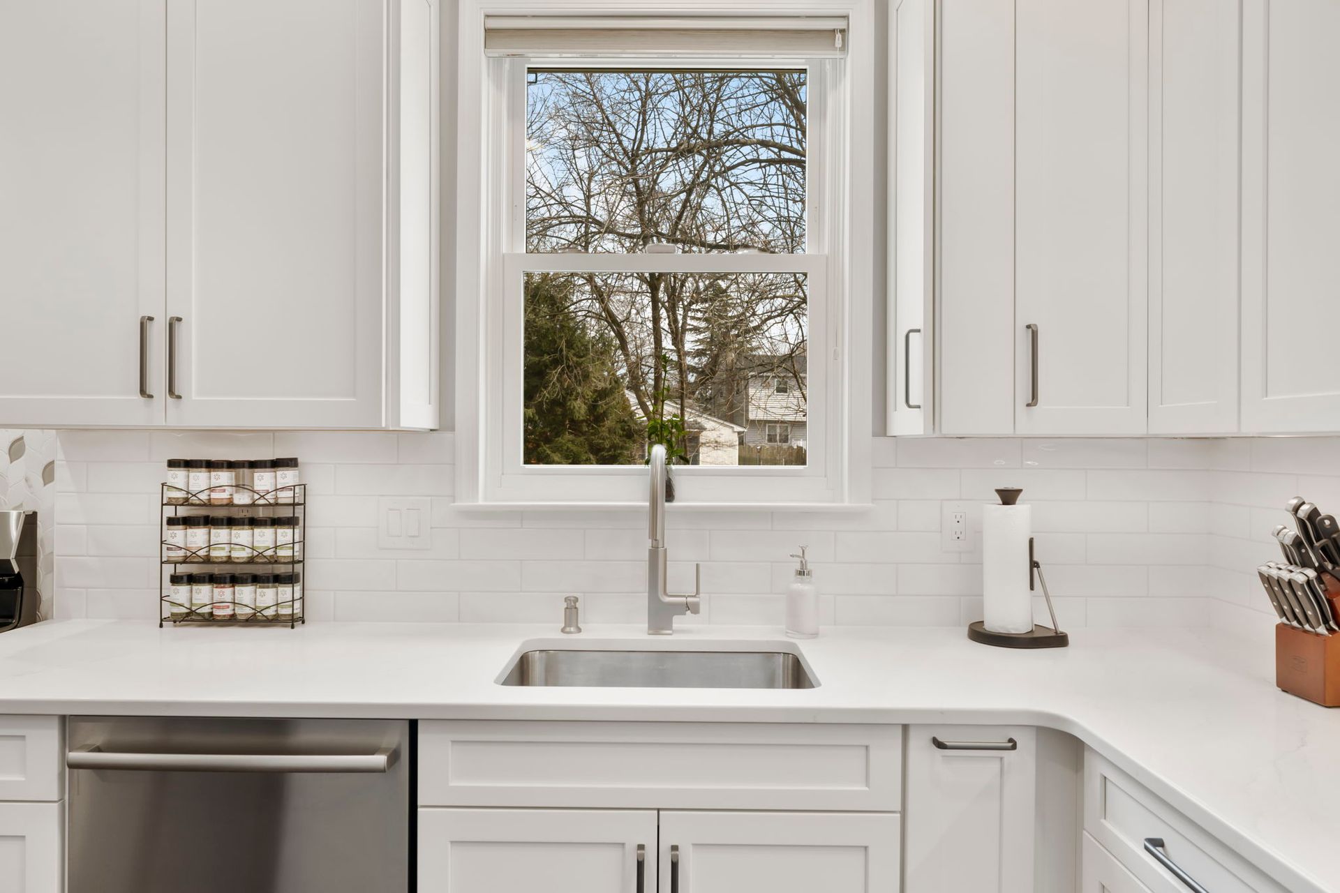 Bright white kitchen with a sink under a window, white cabinets, and stainless steel appliances  In Bucks County PA