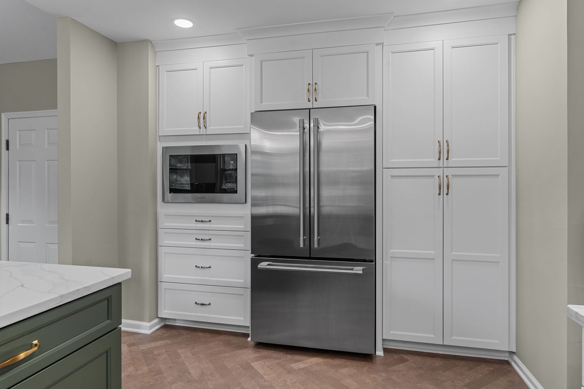 Modern kitchen with white cabinets, stainless steel refrigerator, and built-in microwave In Bucks County PA