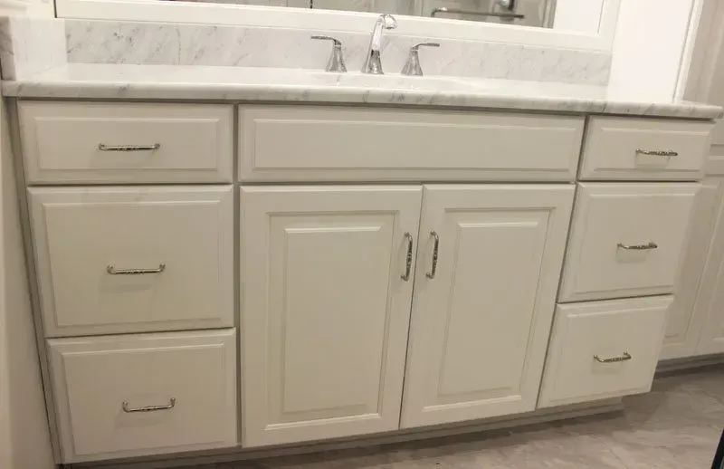 White bathroom vanity with double sink, cabinet doors, and drawers under a marble countertop In Bucks County PA