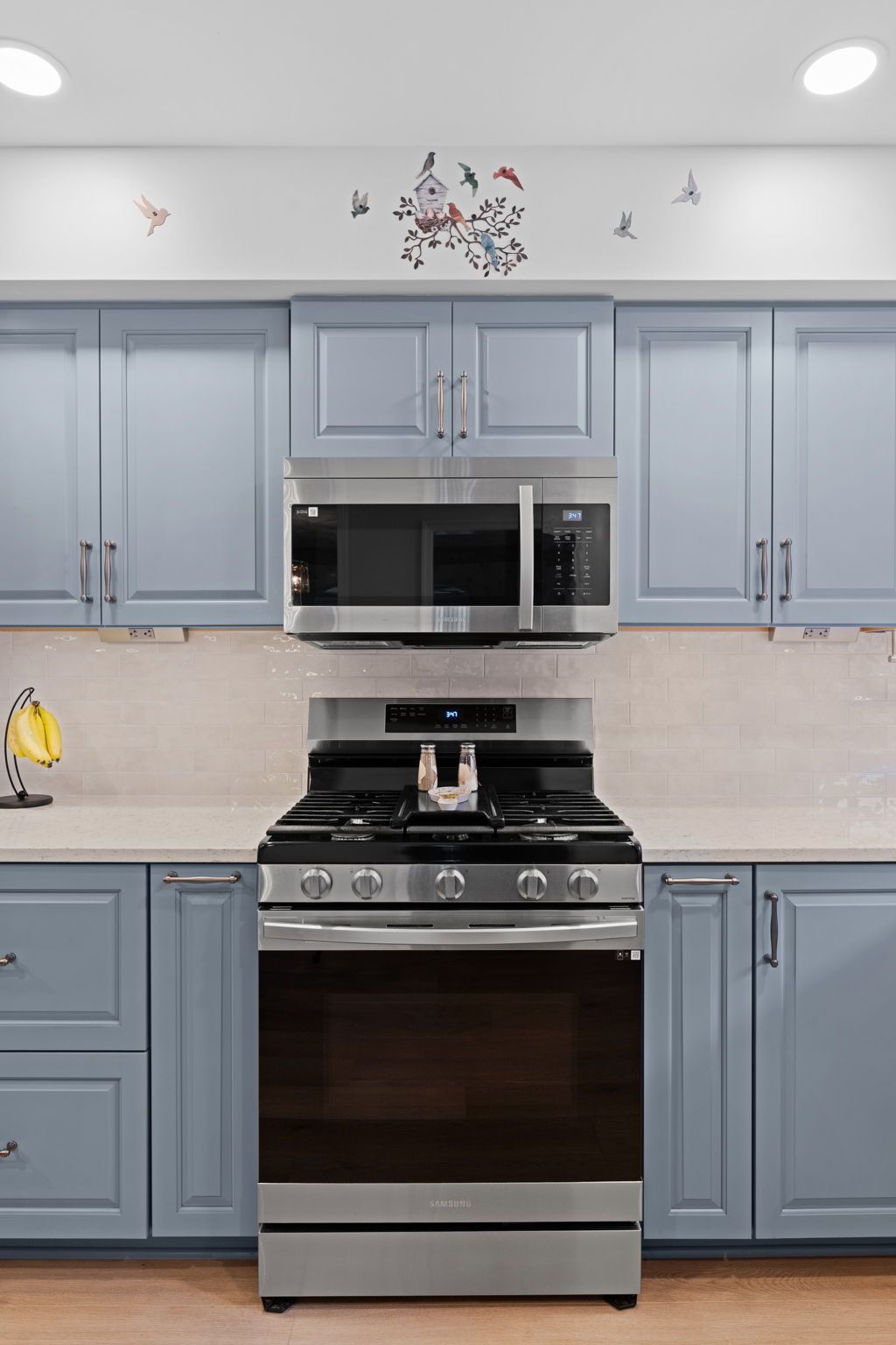 Blue kitchen with stainless steel stove and microwave, light countertops, and upper and lower cabinets In Bucks County PA