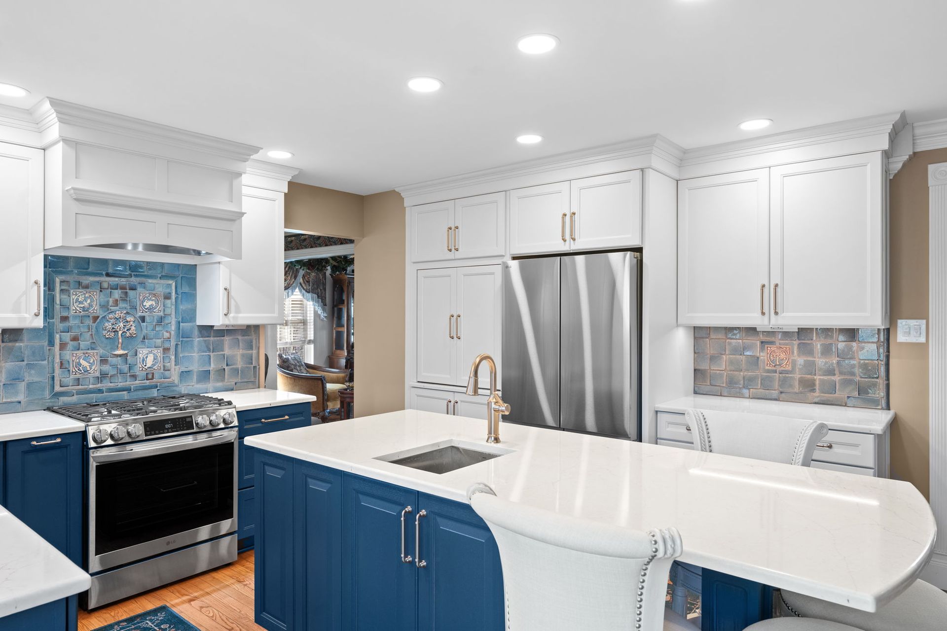 Bright white kitchen with blue island, stainless steel appliances, and mosaic tile backsplash  In Bucks County PA
