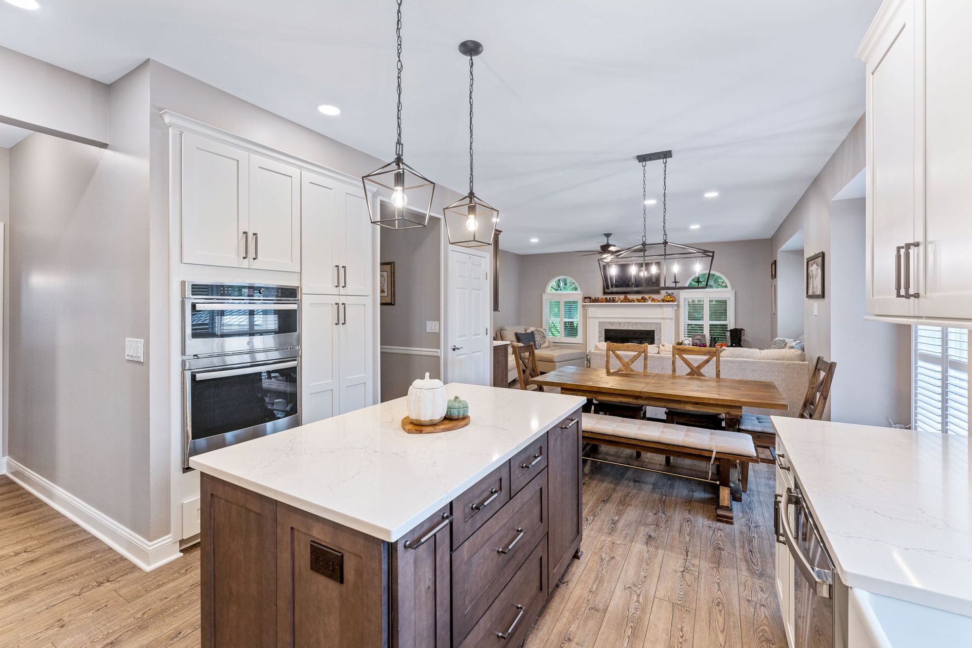 Bright modern kitchen with white cabinets, wood island, and dining table in the background  In Bucks County PA