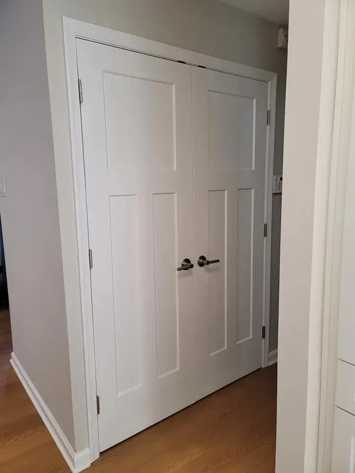 White double closet doors with chrome handles in a hallway with gray walls and wood flooring  In Bucks County PA