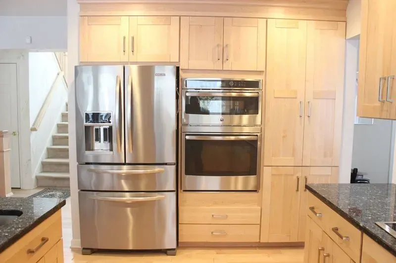 Modern kitchen with stainless steel appliances, light wood cabinets, and granite countertops In Bucks Country PA