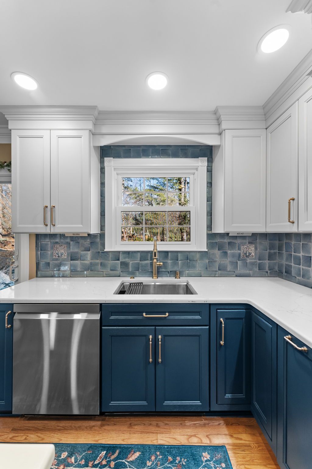 Modern kitchen with white upper cabinets, navy lower cabinets, and a window above the sink  In Bucks County PA  In Bucks County PA