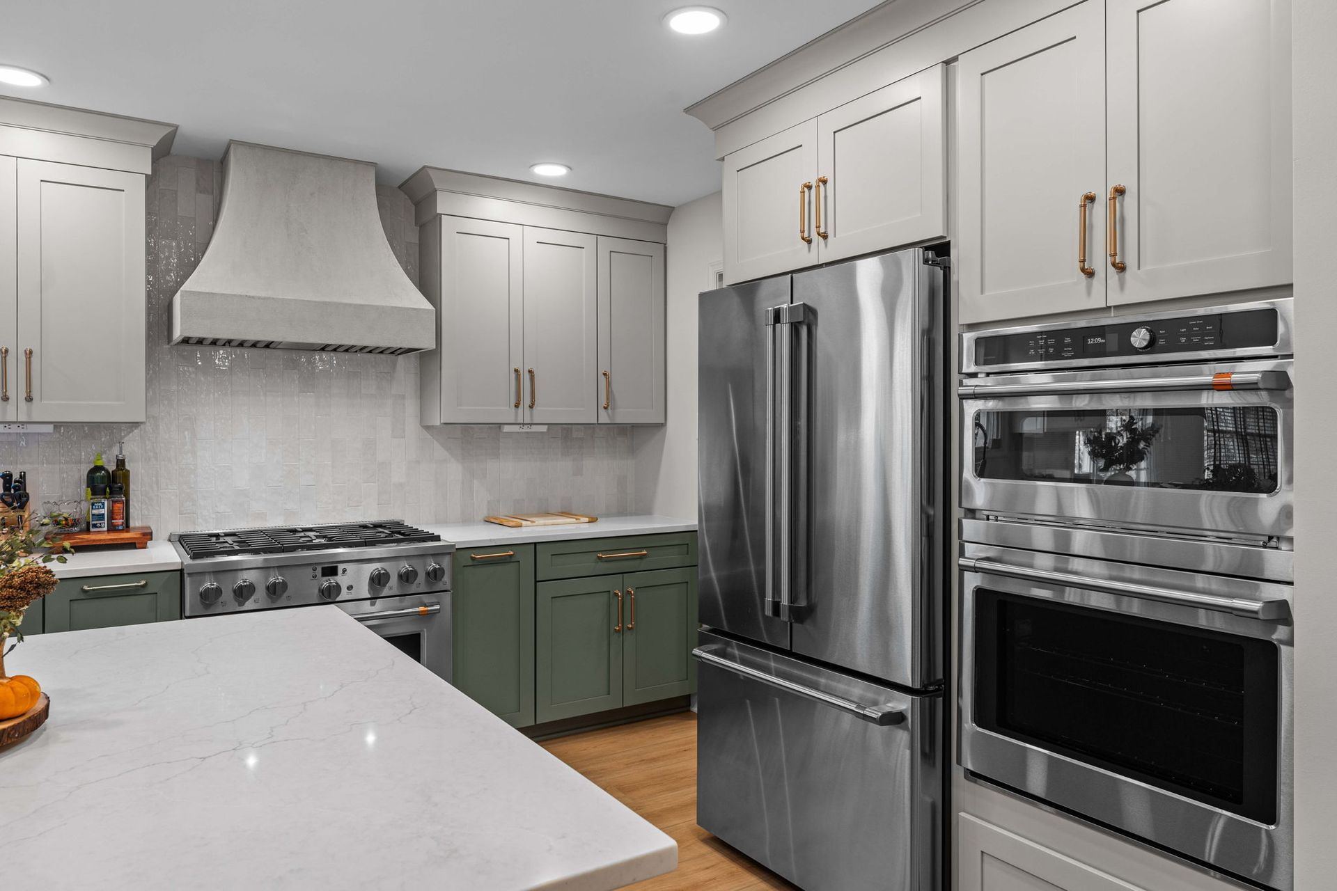 Modern kitchen with white cabinets, stainless steel appliances, and green lower cabinets in Bucks County PA