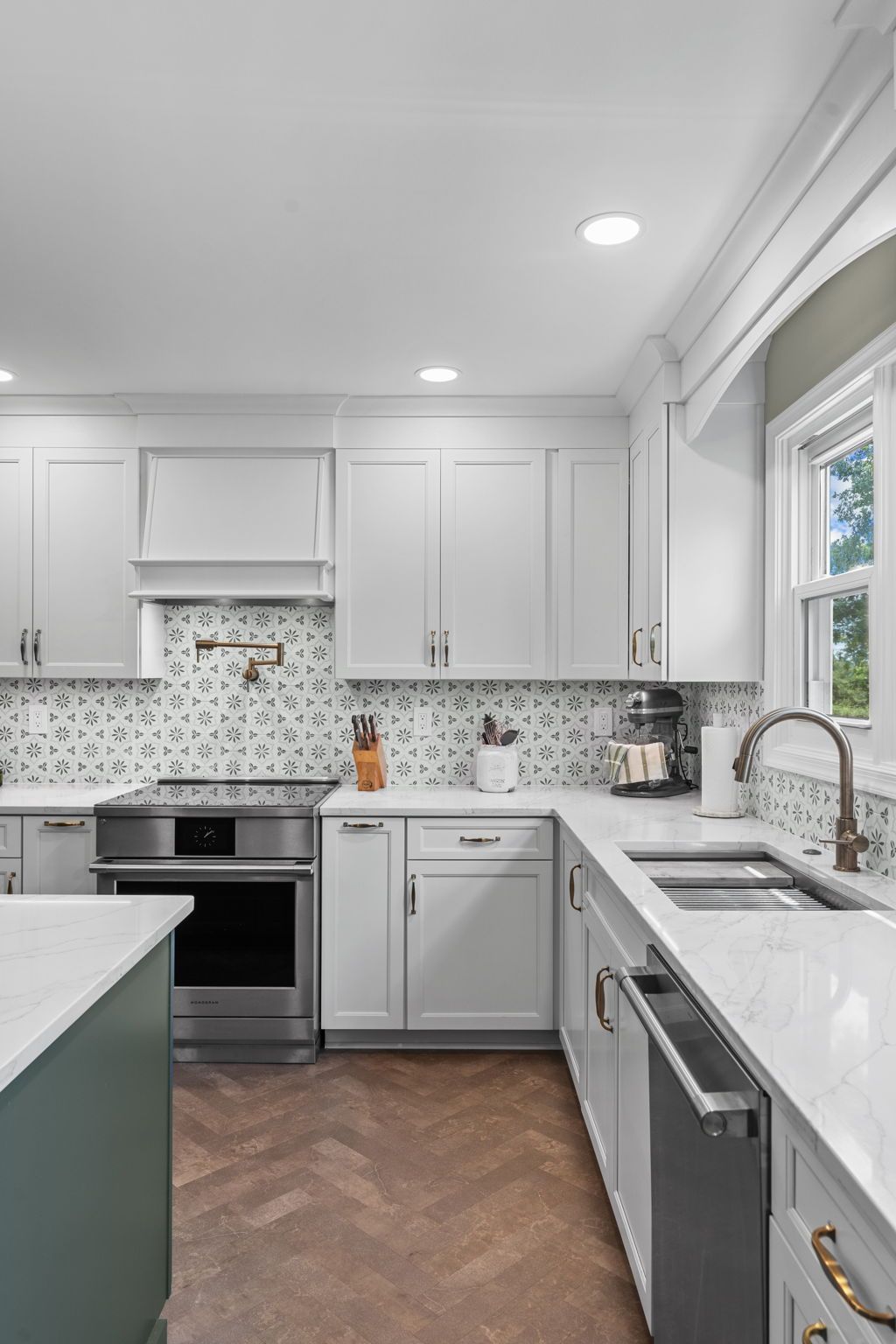 Bright modern kitchen with white cabinets, gray countertops, mosaic backsplash, and stainless steel appliances In Bucks County PA