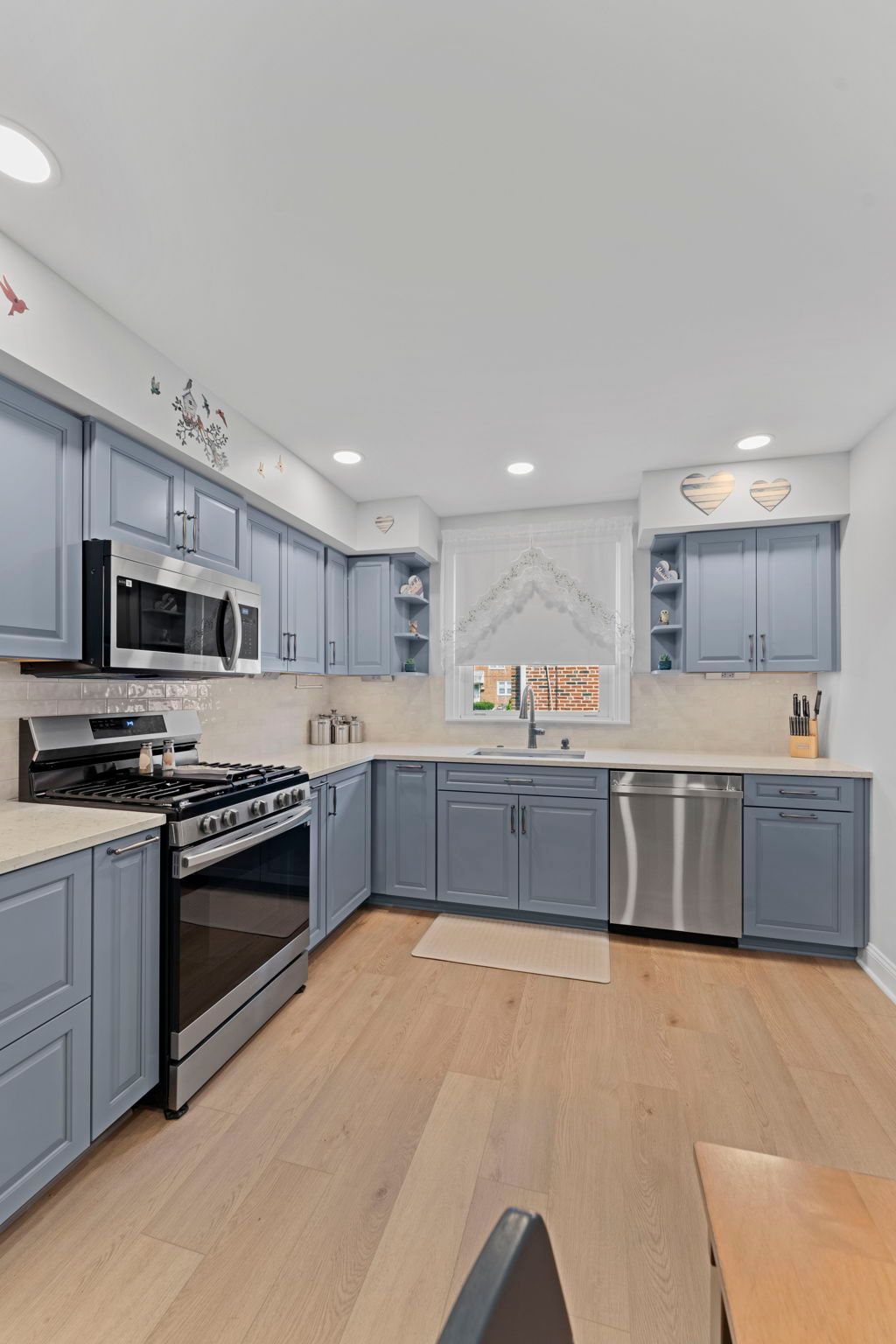 Bright modern kitchen with blue cabinets, stainless steel appliances, and light wood floors In Bucks Country PA