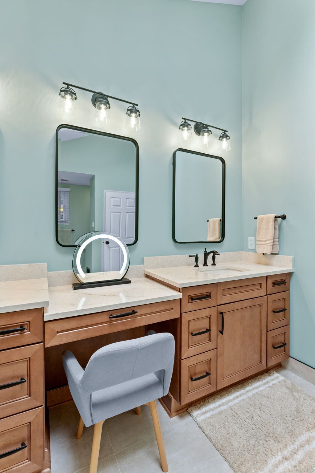 Modern double vanity bathroom with wood cabinets, white countertops, mirrors, and wall sconces In Bucks County PA