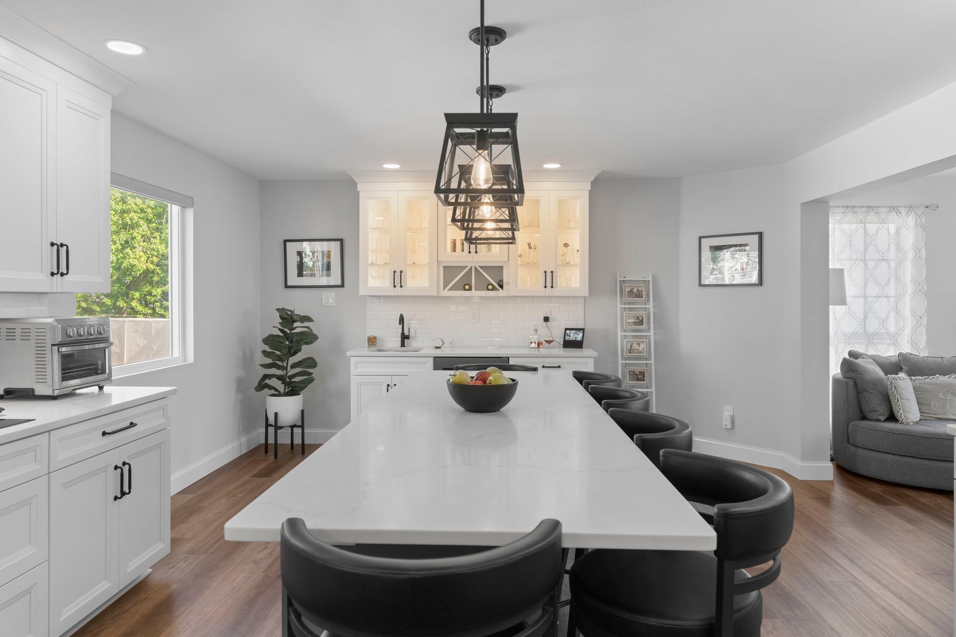 Bright modern kitchen with a large island, white cabinets, pendant light, and open dining and living areas In Bucks County PA