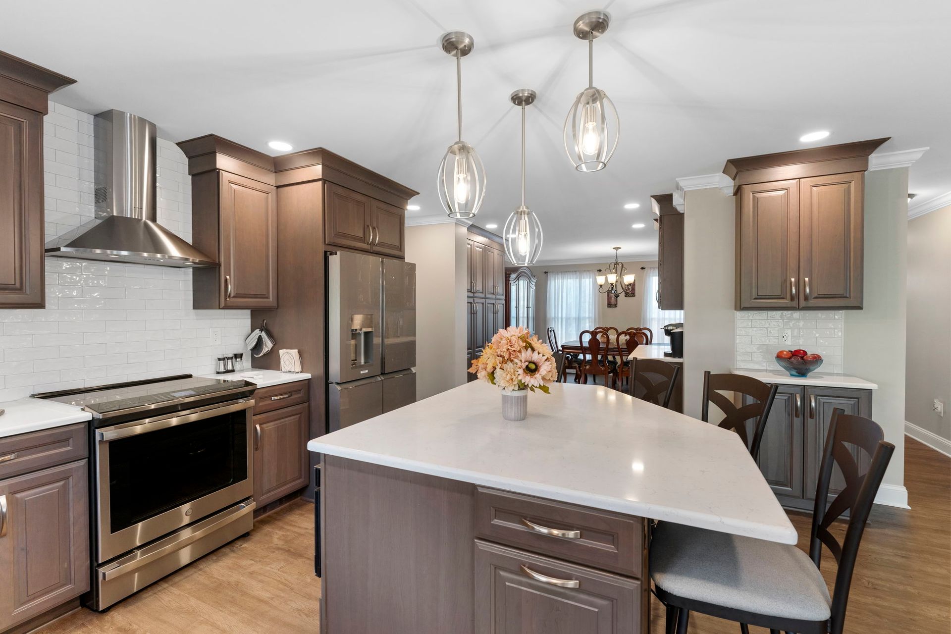 Modern kitchen with island, stainless appliances, pendant lights, and a view into the dining room In Bucks Country PA