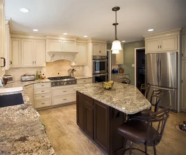 Bright modern kitchen with cream cabinets, granite island, stainless steel appliances, and pendant lights In Bucks Country PA