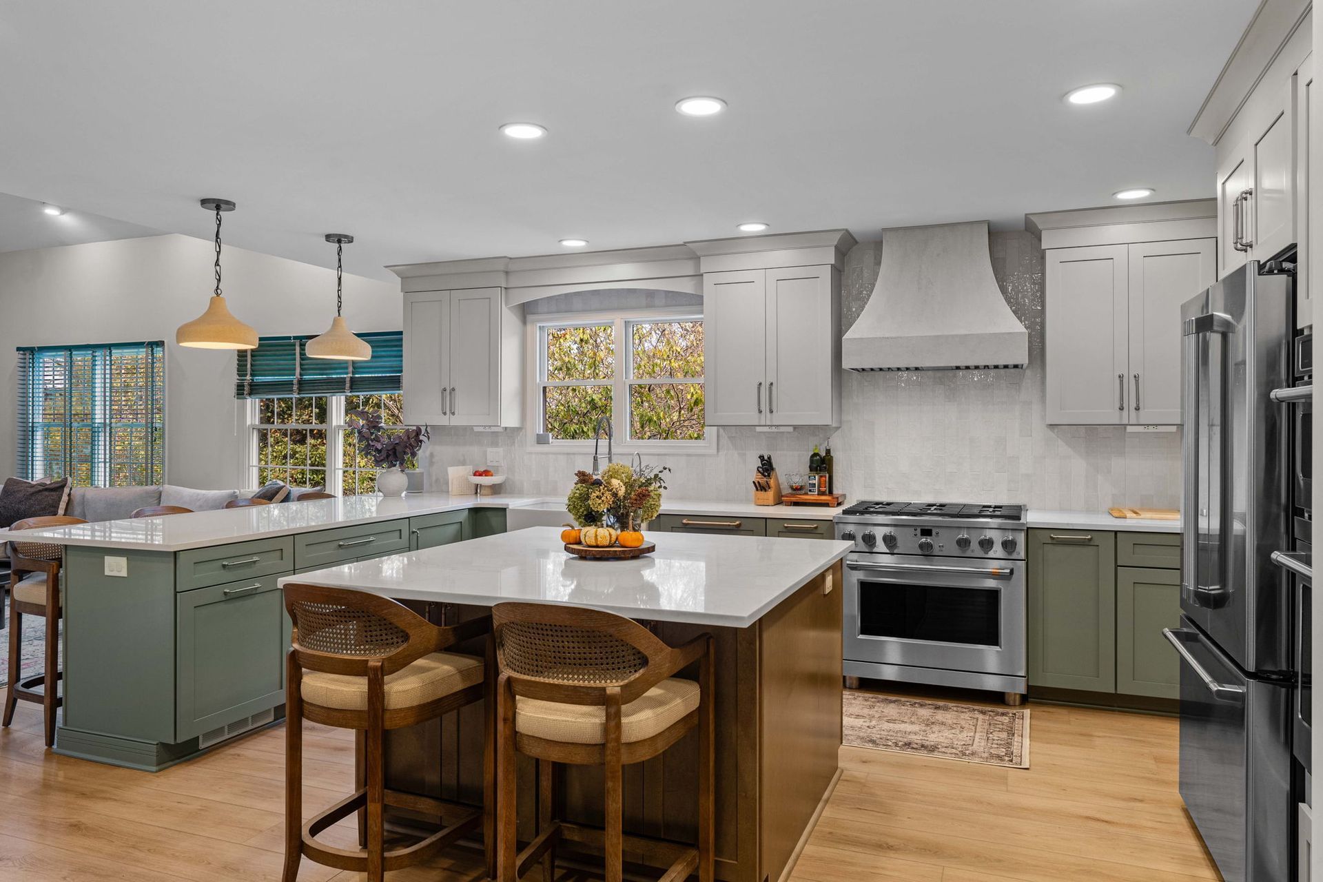 Bright modern kitchen with white island, mint cabinets, stainless appliances, and wooden stools in Bucks County PA