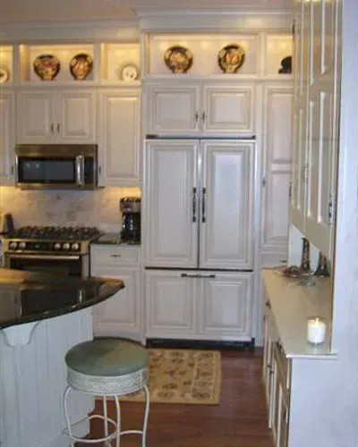 Bright white kitchen with stainless appliances, island stool, and built-in refrigerator In Bucks Country PA
