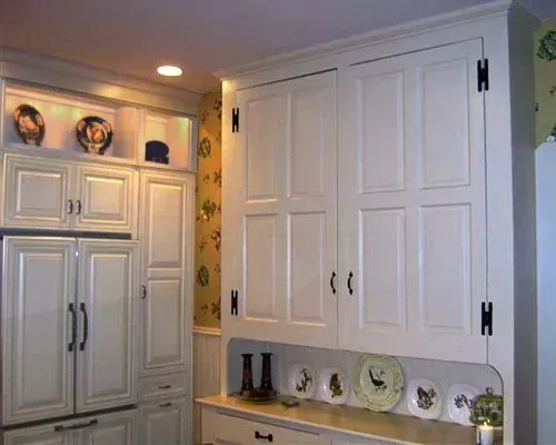 White kitchen cabinets and pantry doors with a built-in display shelf and decorative plates In Bucks County PA