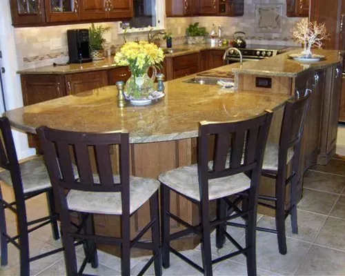 Kitchen island with four stools and a flower centerpiece in a warm-toned home kitchen in Bucks County PA