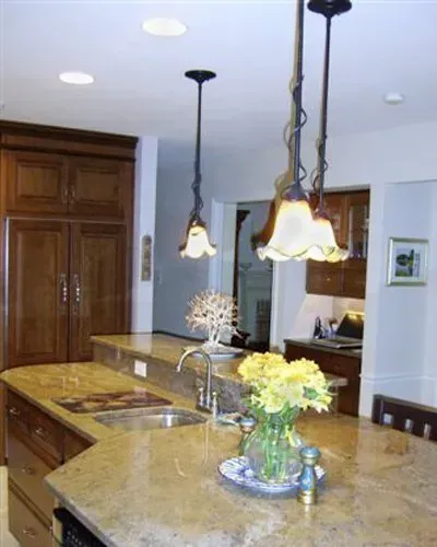 Modern kitchen with granite island, hanging pendant lights, and flowers on the counter in Bucks County PA