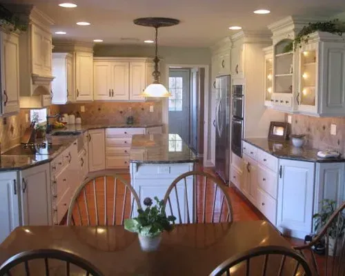 Bright white kitchen with island, stainless steel appliances, and wooden dining table in the foreground In Bucks Country PA