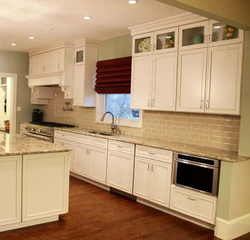 Bright white kitchen with granite counters, wood floor, and stainless steel oven and sink In Bucks Country PA