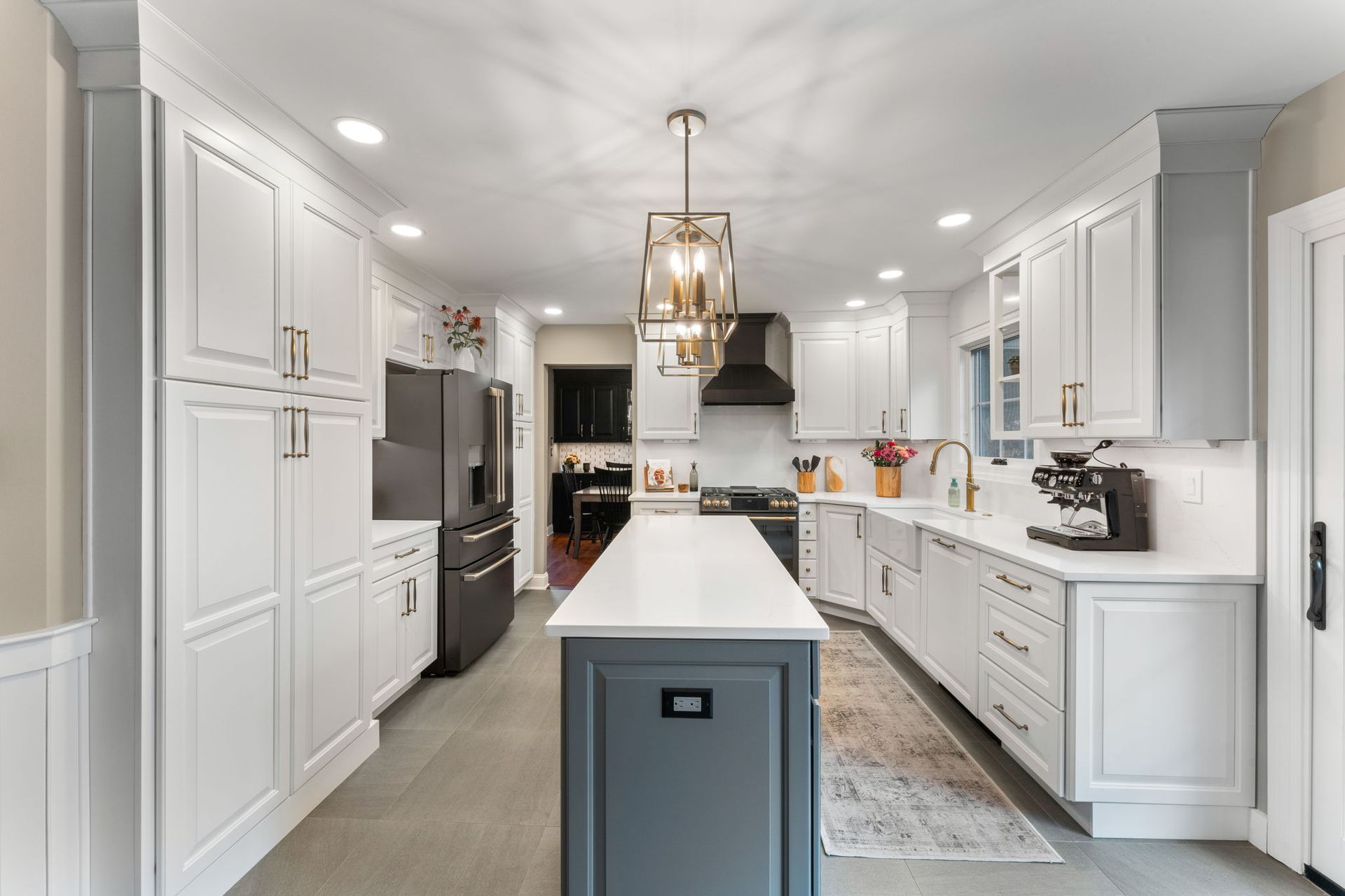 Bright modern white kitchen with a central island, pendant lights, and stainless steel appliances In Bucks Country PA