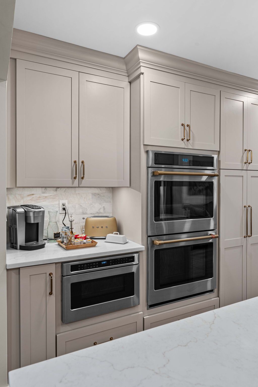 Modern kitchen with beige cabinets, stainless steel built-in ovens, and a white countertop in Bucks County PA