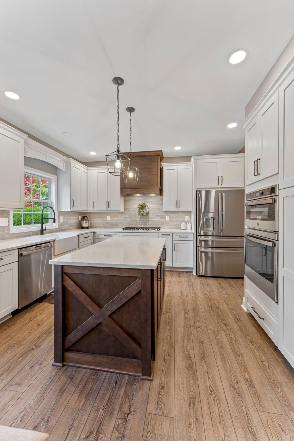 Bright modern kitchen with white cabinets, stainless steel appliances, and a central island with wood paneling  In Bucks County PA