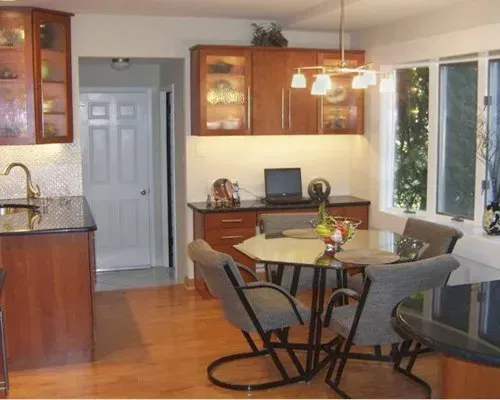 Bright kitchen and dining area with wooden cabinets, round table, chairs, and hanging pendant lights in Richboro PA