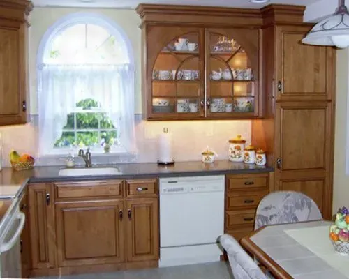 Wooden kitchen with a window over the sink, glass-front cabinets, and a dishwasher under the counter In Bucks County PA