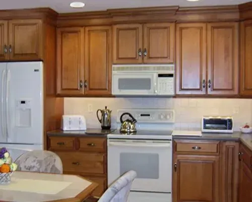 Wooden kitchen with white appliances, countertop decor, and a small dining table in the foreground In Bucks County PA