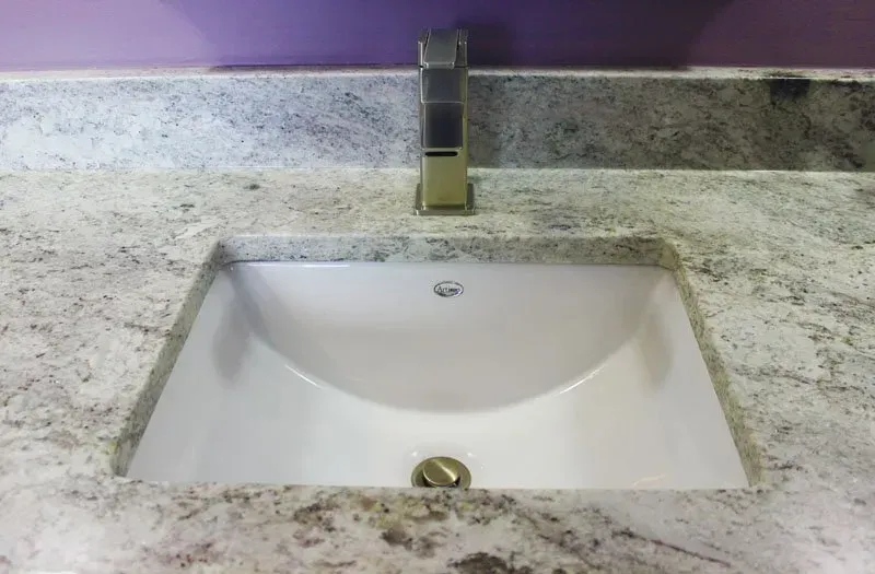 White bathroom sink with chrome faucet set in a light granite countertop in Bucks Country PA