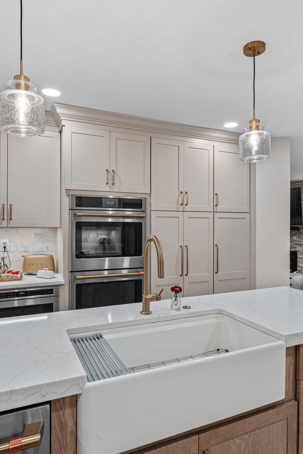 Modern white kitchen with island sink, built-in oven, and pendant lightsin Bucks County PA