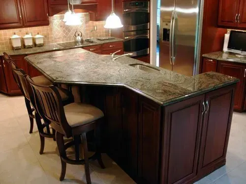 Granite kitchen island with two stools in a warm, wood-paneled kitchen  In Bucks County PA