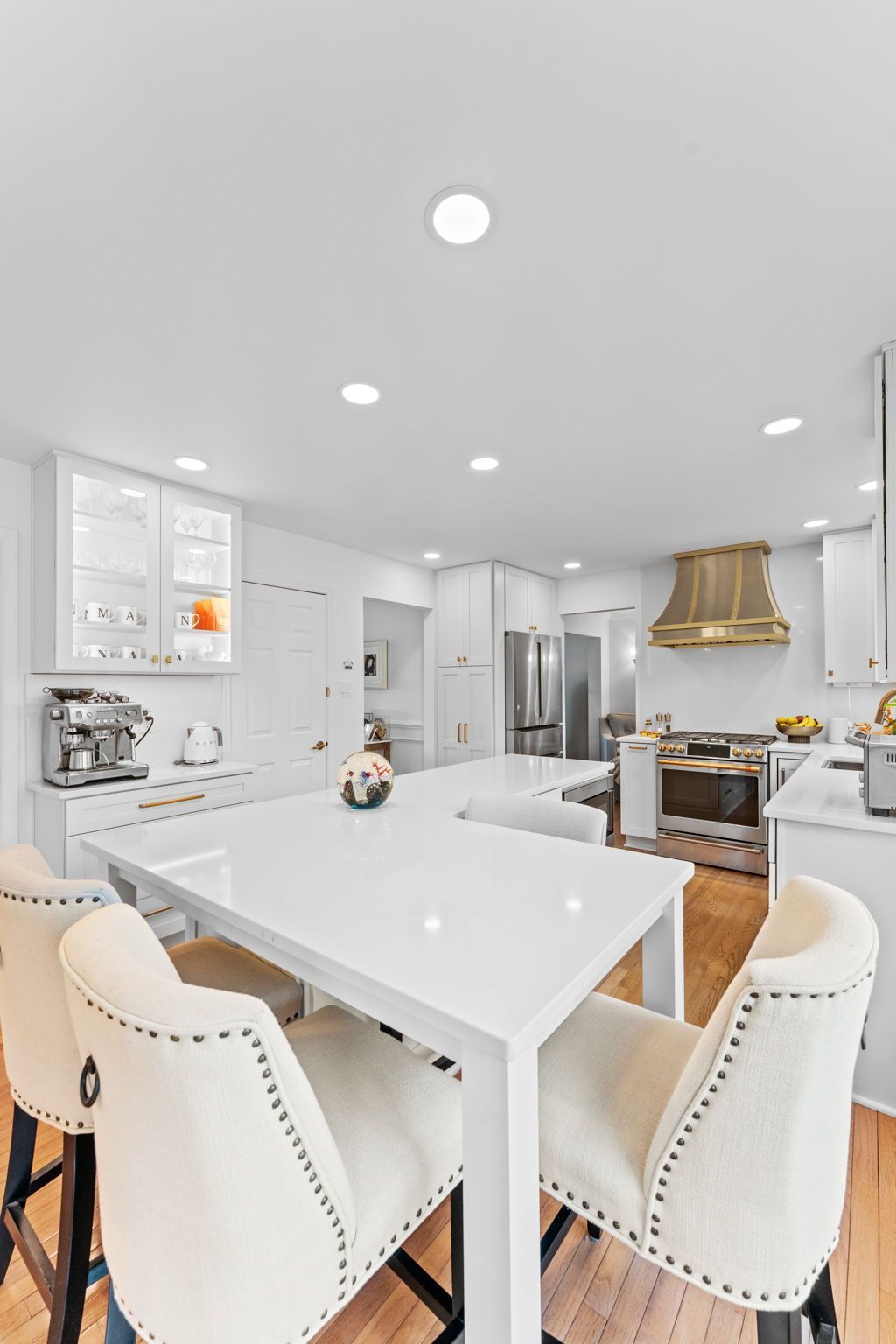 Bright white kitchen and dining area with island, stools, and stainless-steel appliances In Bucks Country PA
