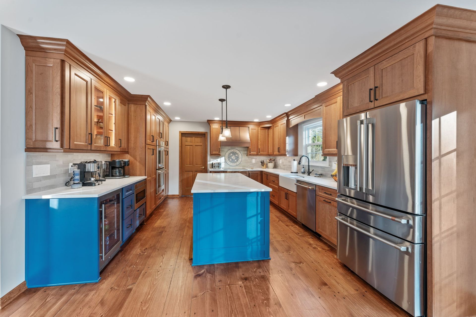 Bright modern kitchen with wood cabinets, stainless appliances, and a blue island centerpiece In Bucks County PA