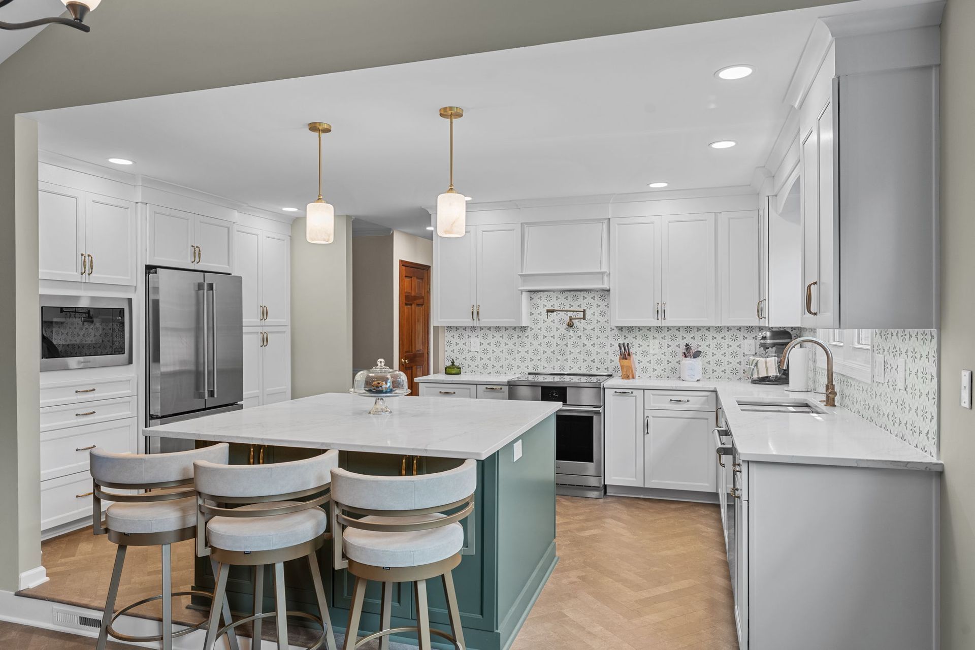 Bright white kitchen with island seating, stainless appliances, and mosaic backsplash In Bucks County PA