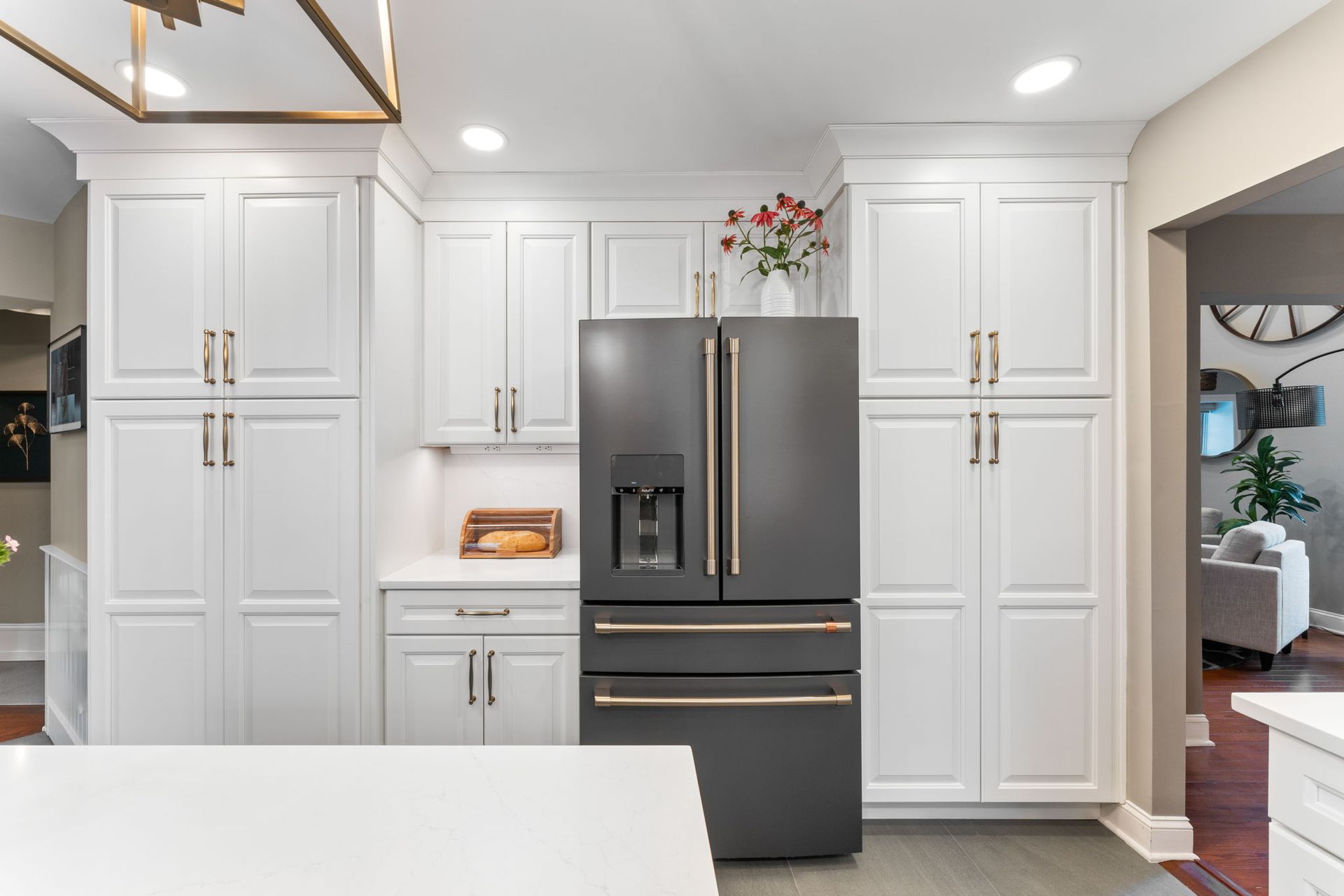 Modern kitchen with white cabinets, dark refrigerator, and wood flooring In Bucks Country PA