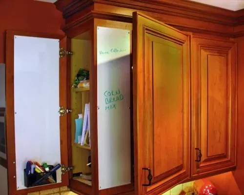 Open wooden kitchen cabinet with frosted glass door and shelves holding cups and papers In Bucks County PA
